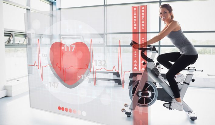 Young girl doing exercise bike with futuristic interface